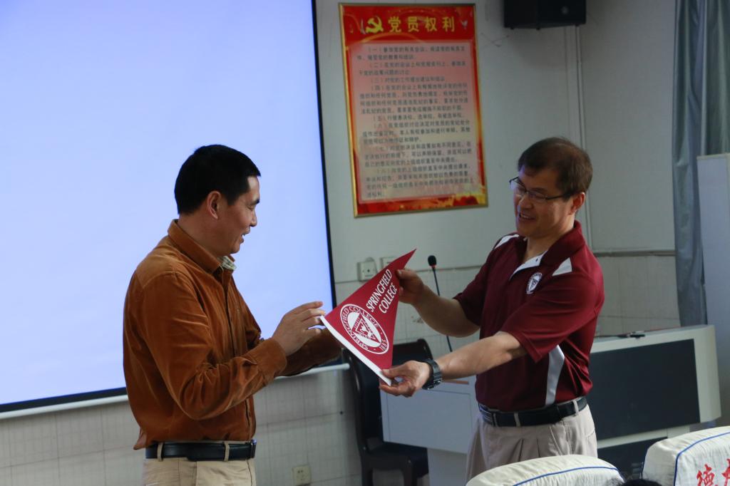 图3 刘展博士向周道平经理赠送美国春田学院校标